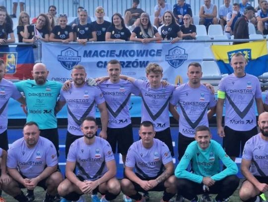 Zawodnicy DJ RW Maciejkowice w fioletowych strojach na wspólnym zdjęciu z kibicami