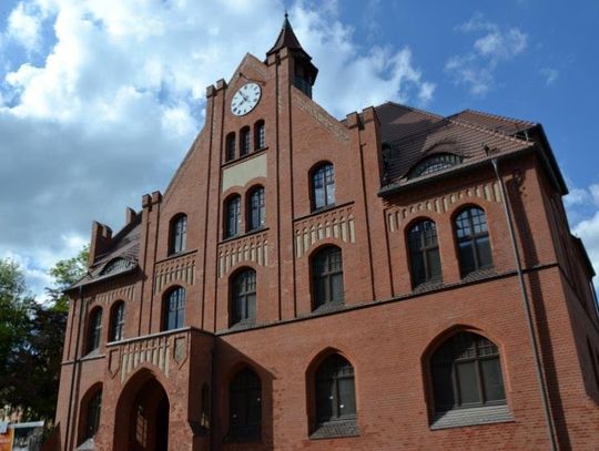Ceglany gmach Muzeum Powstań Śląskich w Świętochłowicach z wieżyczką i zegarem, widziany od frontu.