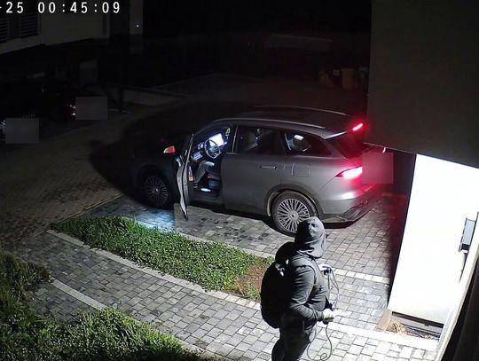 Dwie osoby przy otwartym samochodzie na posesji w Świętochłowicach — kadr monitoringu