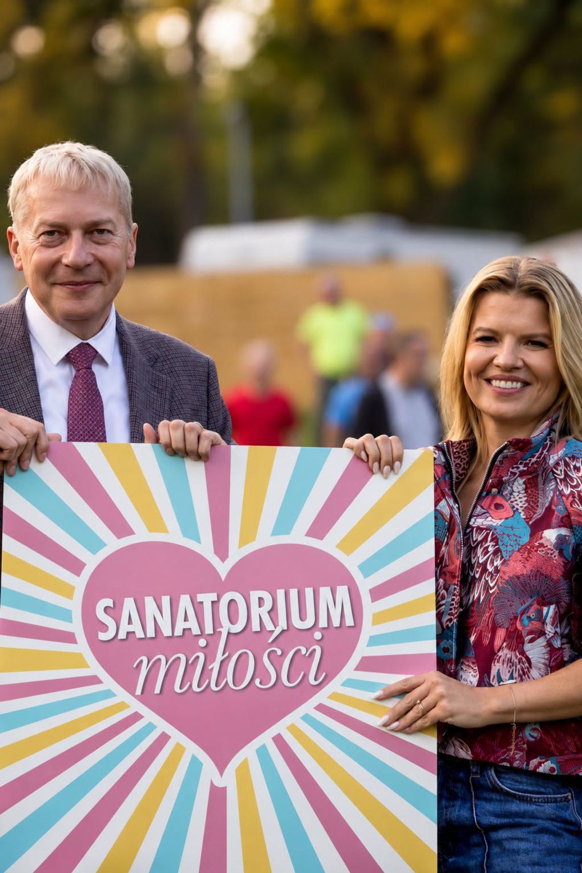 Park Śląski na planie „Sanatorium miłości”. TVP nagrywa dziewiątą edycję Grafika przedstawiająca Wojciecha Saługę i Martę Manowską z planszą „Sanatorium miłości”